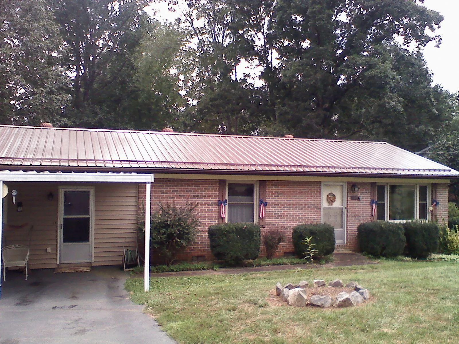 Bronze metal roof and carport on a brick ranch home — Roof Repair work by our crew in Mount Savage