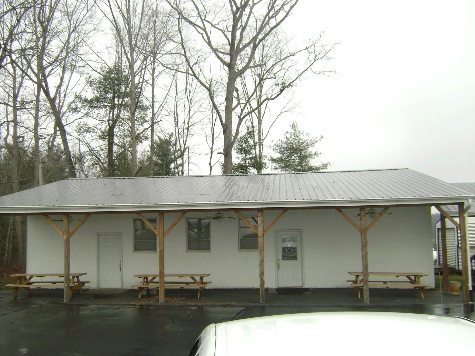Gray metal roof over a block building with a timber post porch in Mount Savage